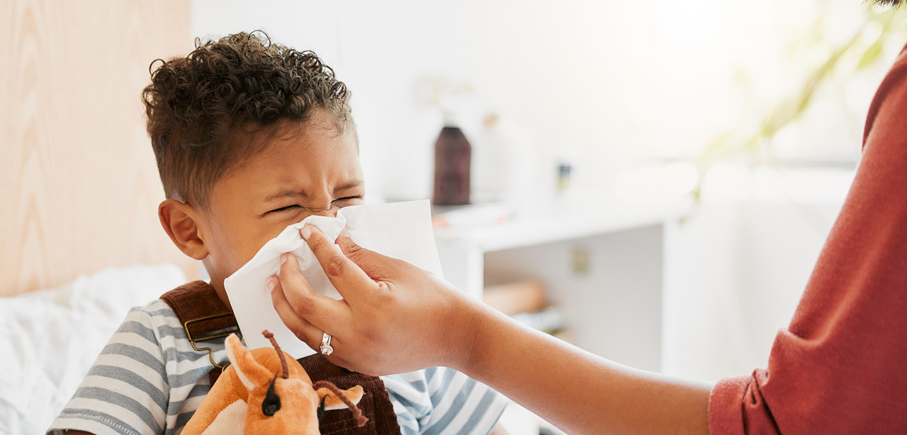 Visuel d'un jeune enfant qui se mouche avec un parent